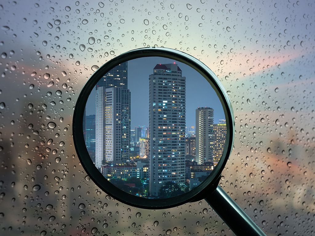 A magnifying glass held in front of a window with condensation