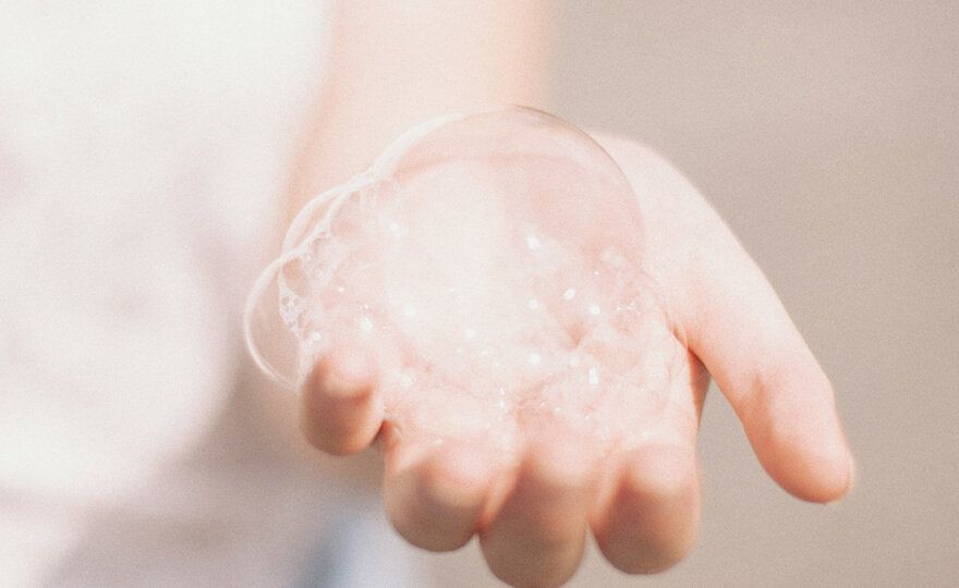 A person holding soap bubbles in their hand